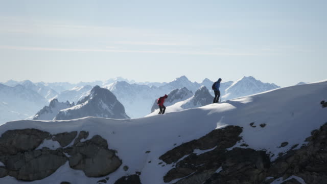 Climbers walk on a snow-covered mountain