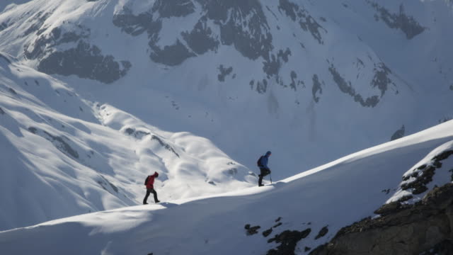 Climbers walk on a snow-covered mountain