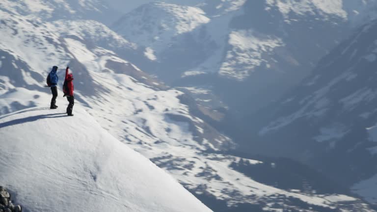 Climbers exultant on a snow-covered mountain peak