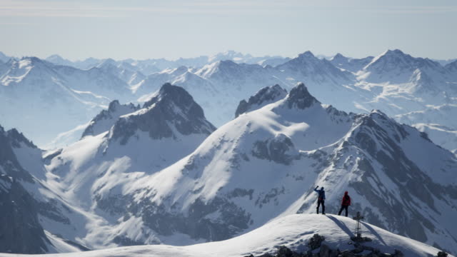 Climbers exultant on a snow-covered mountain peak