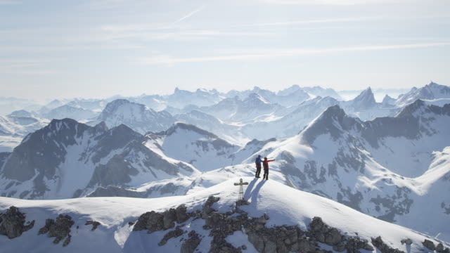 Climbers standing on a snow-covered mountain peak