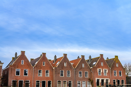 This is a photograph of a row of red brick houses on a winter day in Muiden, Netherlands.