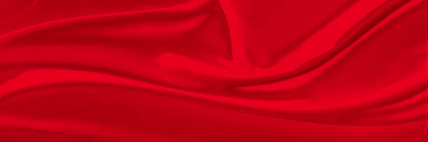 istock Black red satin dark fabric texture luxurious shiny that is abstract silk cloth background with patterns soft waves blur beautiful. 1714151334