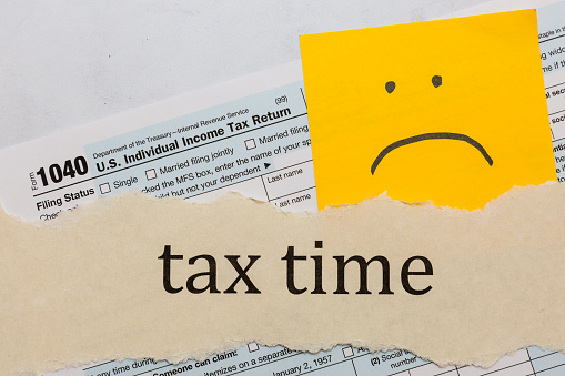 Tax time with 1040 IRS form and sad face