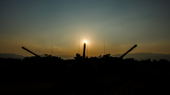 wide angle shot silhouette of tank gun truck and over the sunset background,