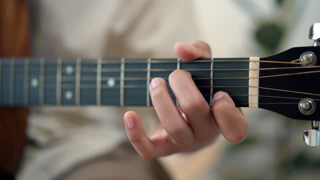 Male hands playing acoustic guitar