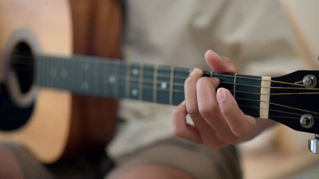 Asian male hands playing guitar