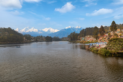 Beautiful Mirik lake with view of cityscape and the majestic Kanchenjunga Himalaya mountain range in the backdrop. Mirik is a scenic hill station located in district of Darjeeling, India.