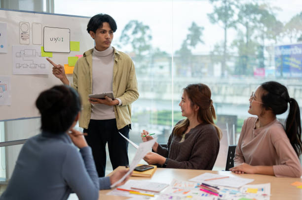 istock Young smart UX UI designer presenting his idea to the team, presentation during the team meeting. 1714371175