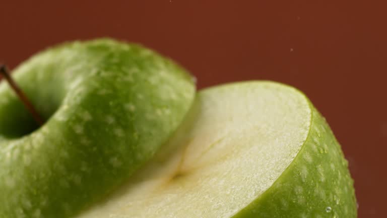 Rotating a wet apple in slow motion. Slicing the fruit