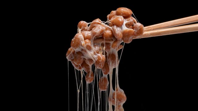 4K slow motion video of natto falling off chopsticks.