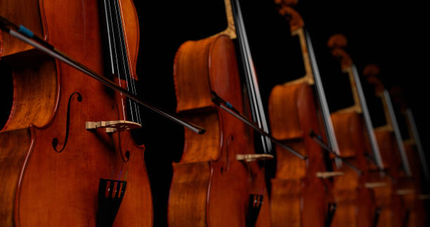 istock cellos on a black background, dancing in an abstract dance, fantasy, background for classical music, 3d render 1714419013