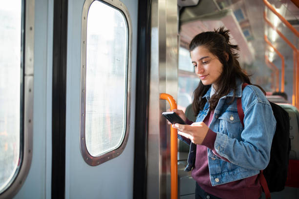 istock Woman texting on her phone while taking the underground. 1714438032