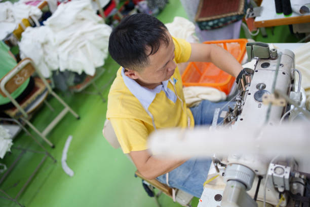 istock Male sewing worker in garment factory 1714438629