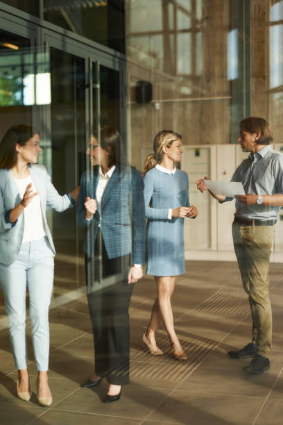 istock Happy business colleagues talking in a hallway. 1714471666