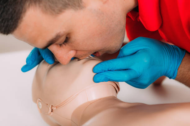 istock CPR with mouth to mouth technique in a first aid course using a training dummy 1714477081