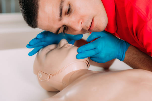 istock CPR with mouth to mouth technique in a first aid course using a training dummy 1714477086