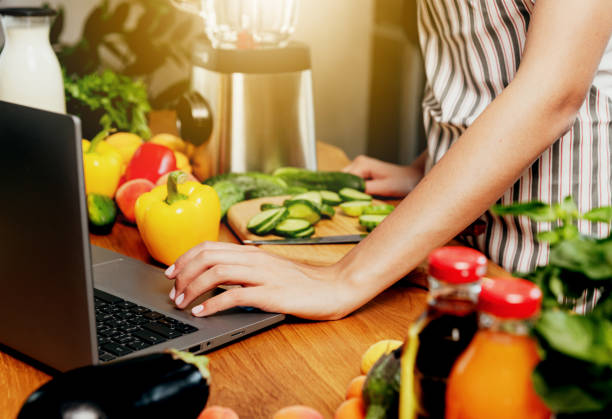 istock Kitchen. Young woman using laptop for recipe, girl hand click, touch computer 1714488673