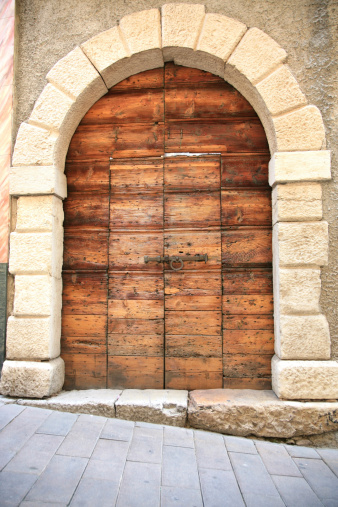 A huge wooden gate with built in door in Italy.