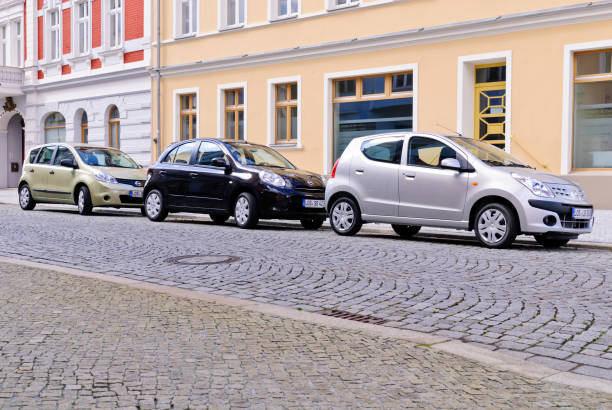 Bucharest, Romania - May 23, 2023: Vehicles navigate a bustling intersection in Bucharest Romania featuring grand historic architecture under cloudy skies. The urban setting captures a blend of modern and historical elements.