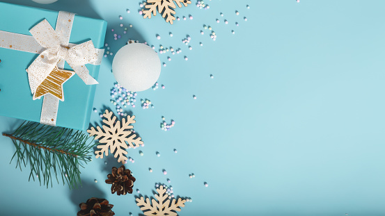 Christmas composition with gift boxes, decorations, snowflakes on a light blue background. Top view. Copy space