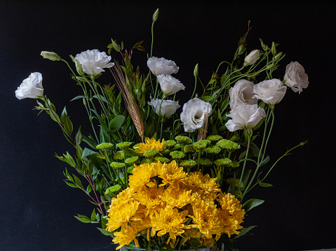 Bouquet of small green chrysanthemums with long branches of lisianthus and yellow daisies