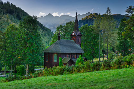 Beautiful landscape of the Tatra Mountains with a wooden church in the morning, Slovakia.