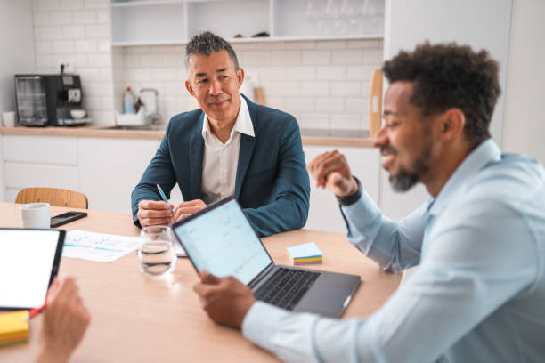 istock Productive Brainstorming in Modern Office with Diverse Professionals Using Laptop and Digital Tablet 1714543173