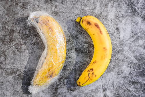 Bananas with natural peel wrapped in pointless plastic packaging
