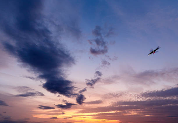 avião pousando no céu nublado do pôr do sol. conceito de fim de dia - rasto de fumo de avião - fotografias e filmes do acervo