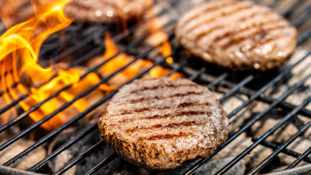 istock Burger patties roasting on a charcoal grill 1714600168