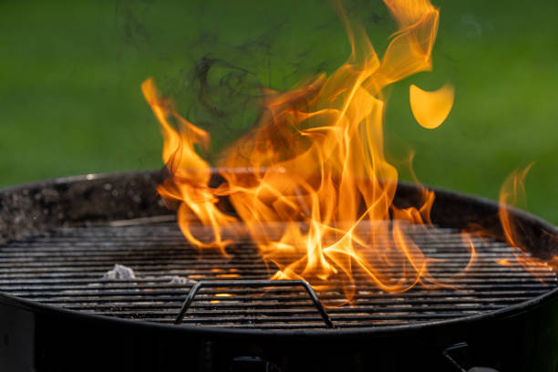istock Flaming barbecue grill on green background 1714600757