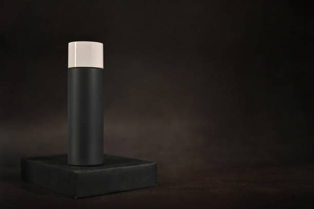 Men cosmetic bottle with water drop on dark background, cosmetic packaging template design.