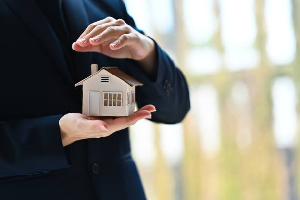 istock Man hands protecting house model. Property insurance, security and real estate concept 1714606784