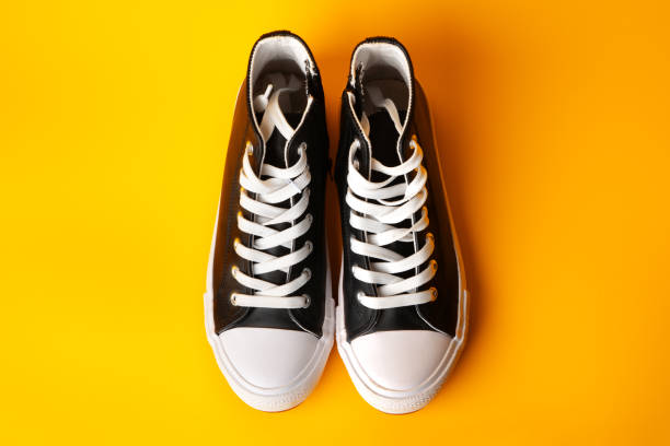 istock New black and white canvas sneakers on yellow background 1714613395