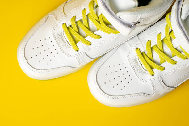 istock White sneakers with yellow neon laces on yellow background 1714622671