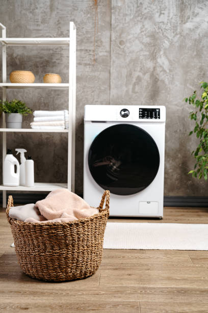 istock Laundry room interior with washing machine near gray grunge wall 1714622676