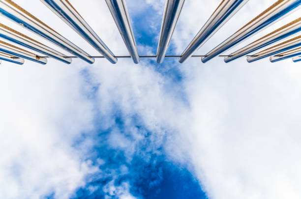 istock Fence with tall metal bars pointing to the blue sky with perspective viewed from below. 1714635940