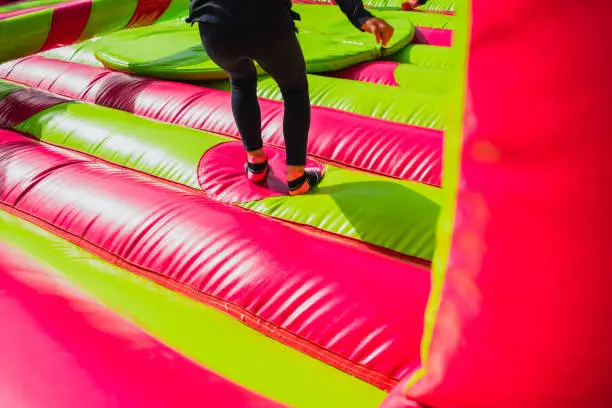 Girl jumping and exercising while having fun in an inflatable castle to bounce.