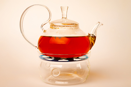Transparent glass teapot with tea isolated on white background