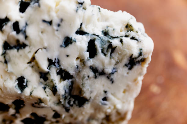Macro close-up of a French blue cheese roquefort, tangy, crumbly and slightly moist, with distinctive veins of blue mold. Macro close-up of a French blue cheese roquefort, tangy, crumbly and slightly moist, with distinctive veins of blue mold. tangy stock pictures, royalty-free photos & images