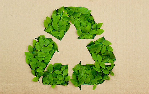 Recycling symbol made of white paper and used batteries placed under it
