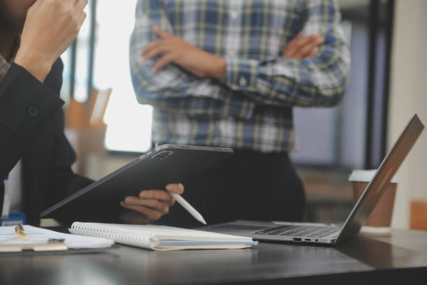istock Financial analysts analyze business financial reports on a digital tablet planning investment project during a discussion at a meeting of corporate showing the results of their successful teamwork. 1714693395