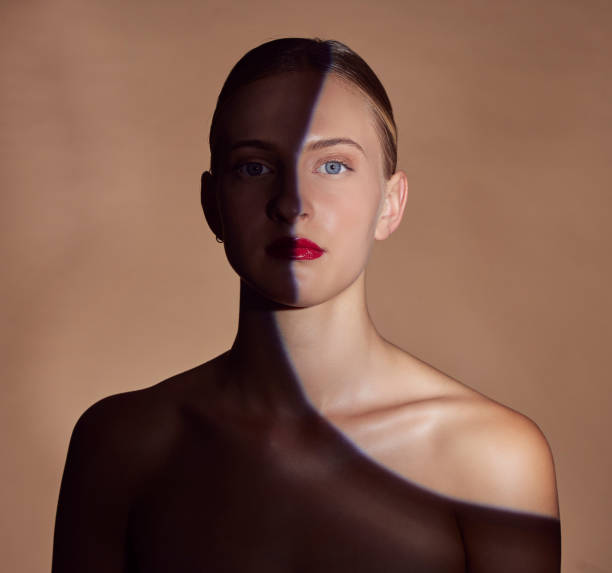 istock Spotlight, portrait or shadow for lipstick, beauty or creative aesthetic with light on studio background. Model, face or woman with dark side or art style for skincare, makeup or facial cosmetics 1714693538