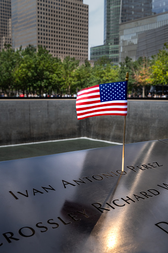 9/11 Memorial Pool, Ground Zero, New York, USA - September 16, 2023. The Stars and Stripes American Flag used as a tribute to the victims of the 9/ll attack at the Ground Zero memorial pool in New York City