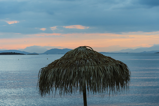 Umbrella on a Greek beach near Athens at sunset. High quality photo
