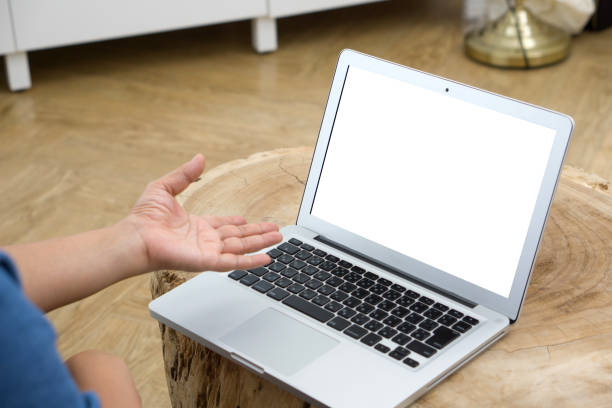 istock An individual engrossed in work on a white screen laptop. The laptop is perched on a richly grained wooden table, exuding an ambiance of productivity and focus 1714712791