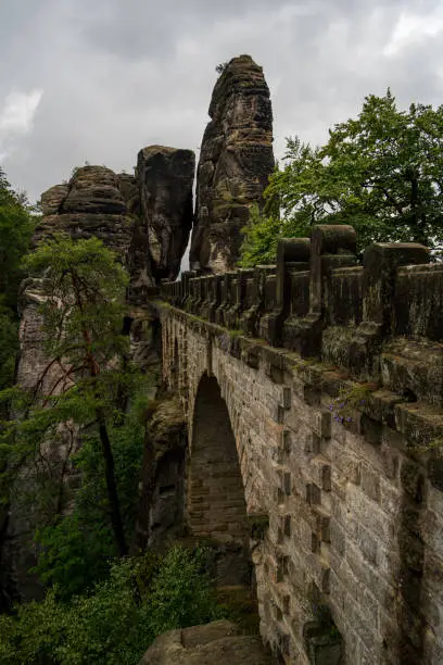 The Basteibridge in Germany during the morning on a cloudy day with some fog hanging around