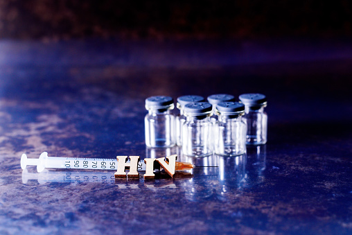 Vials and syringe with samples of the new vaccine against HIV, Human Immunodeficiency Virus.