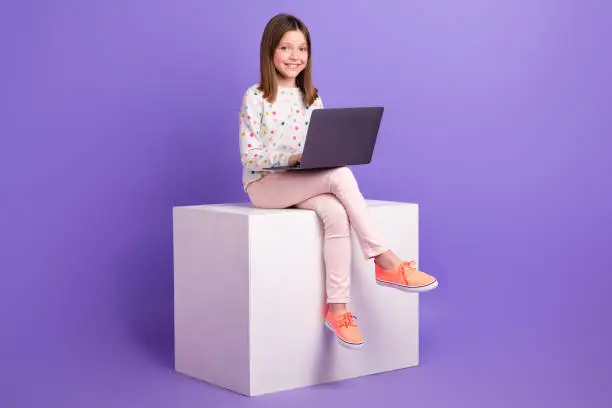 Full length photo of positive good mood small girl wear dotted sweater chatting apple samsung modern gadget isolated violet color background.